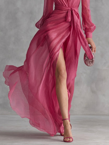 Elegante vestido largo de mujer en gasa rosa perla con escote en V y cinturón en la cintura.